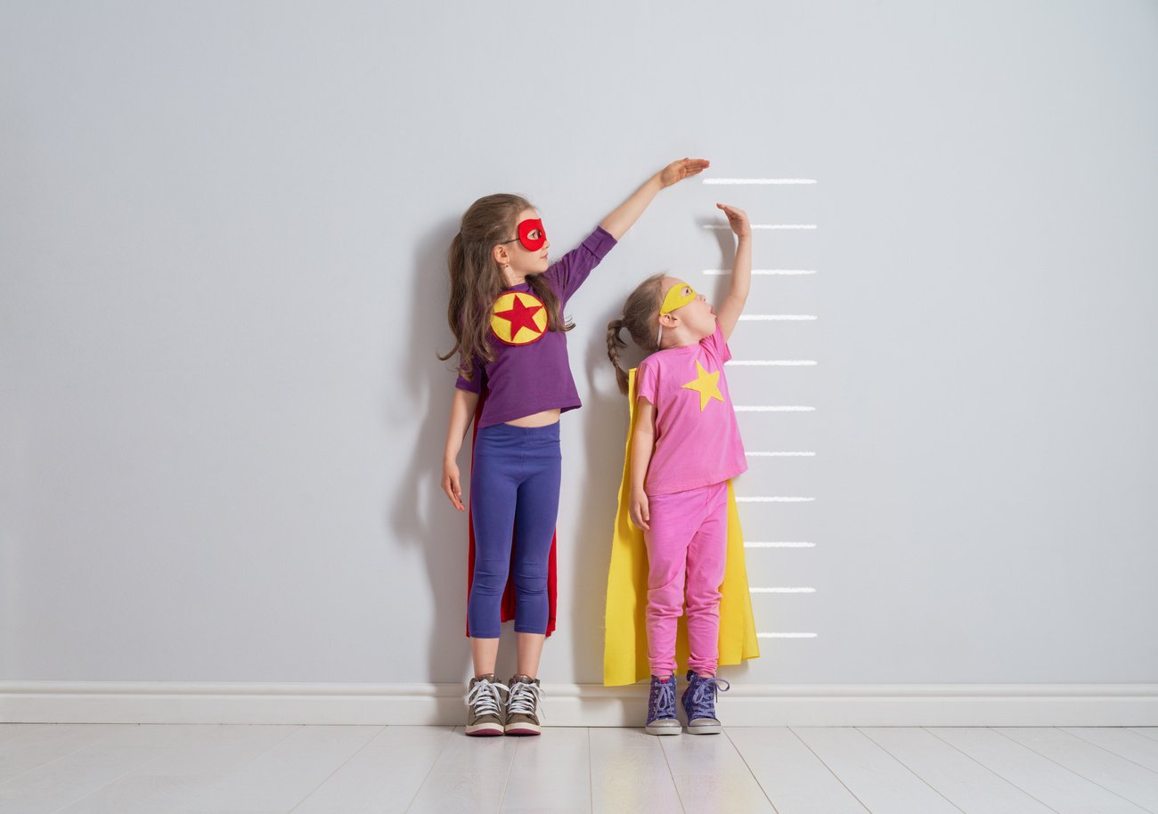 Pediatric GI health. Two children measuring their heights.