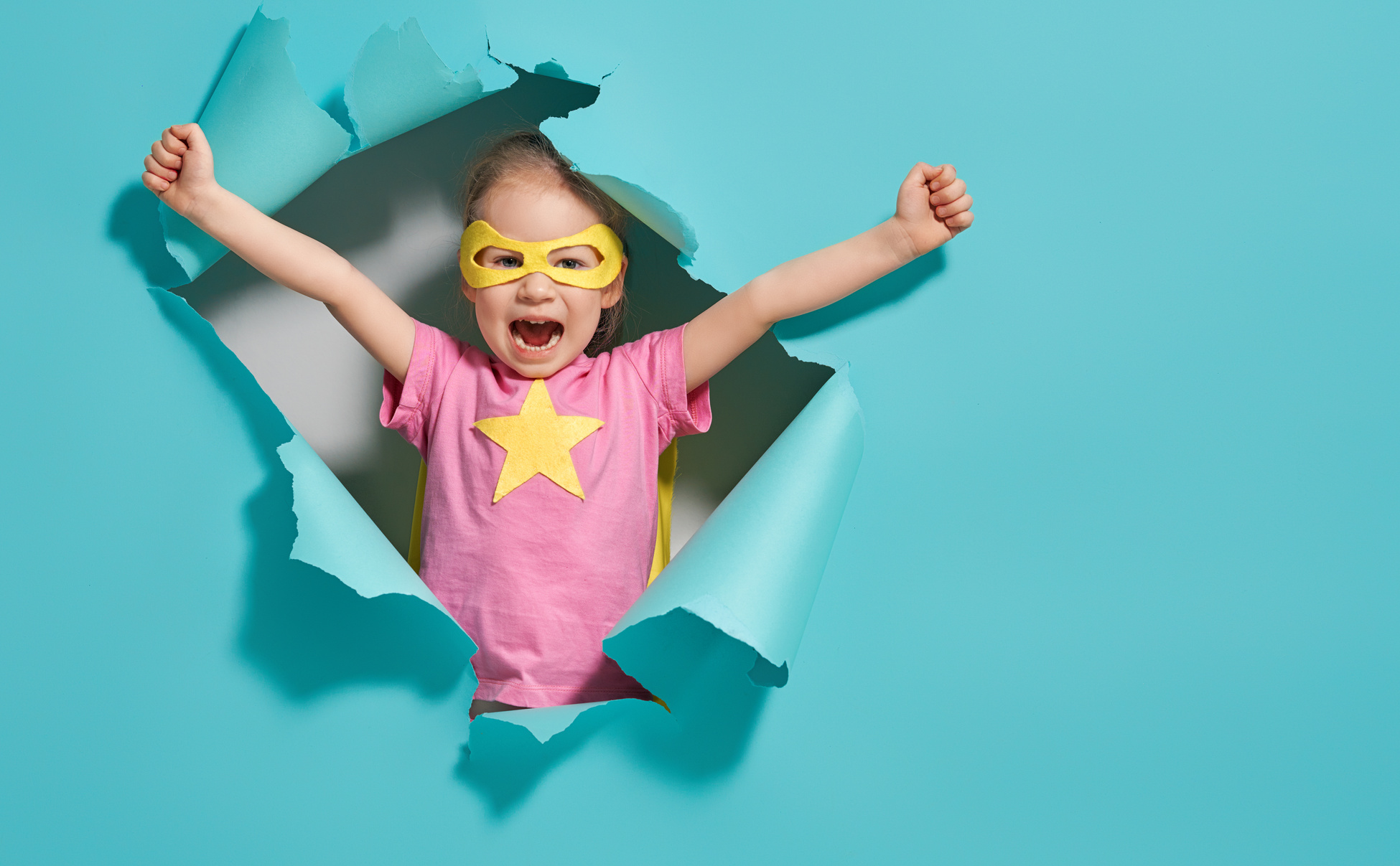 Pediatric GI. A little person in a superhero costume peeking through a hole in a blue wall